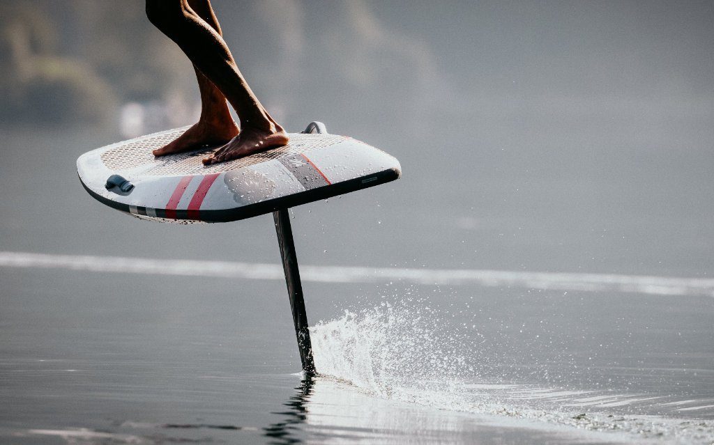 Close-up van een eFoil-board dat boven het water vliegt, met de mast door het wateroppervlak