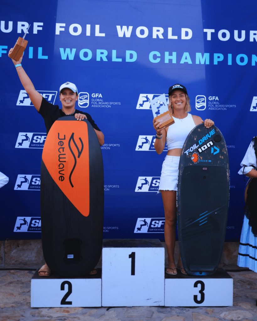 Twee rijders met hun eFoil-board op het podium van de Surf Foil World Tour, op de plekken 2 en 3